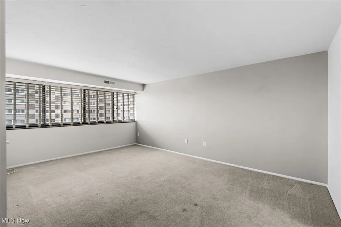 Spare room featuring carpet and baseboards