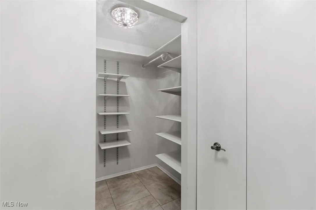 Spacious closet with light tile patterned floors