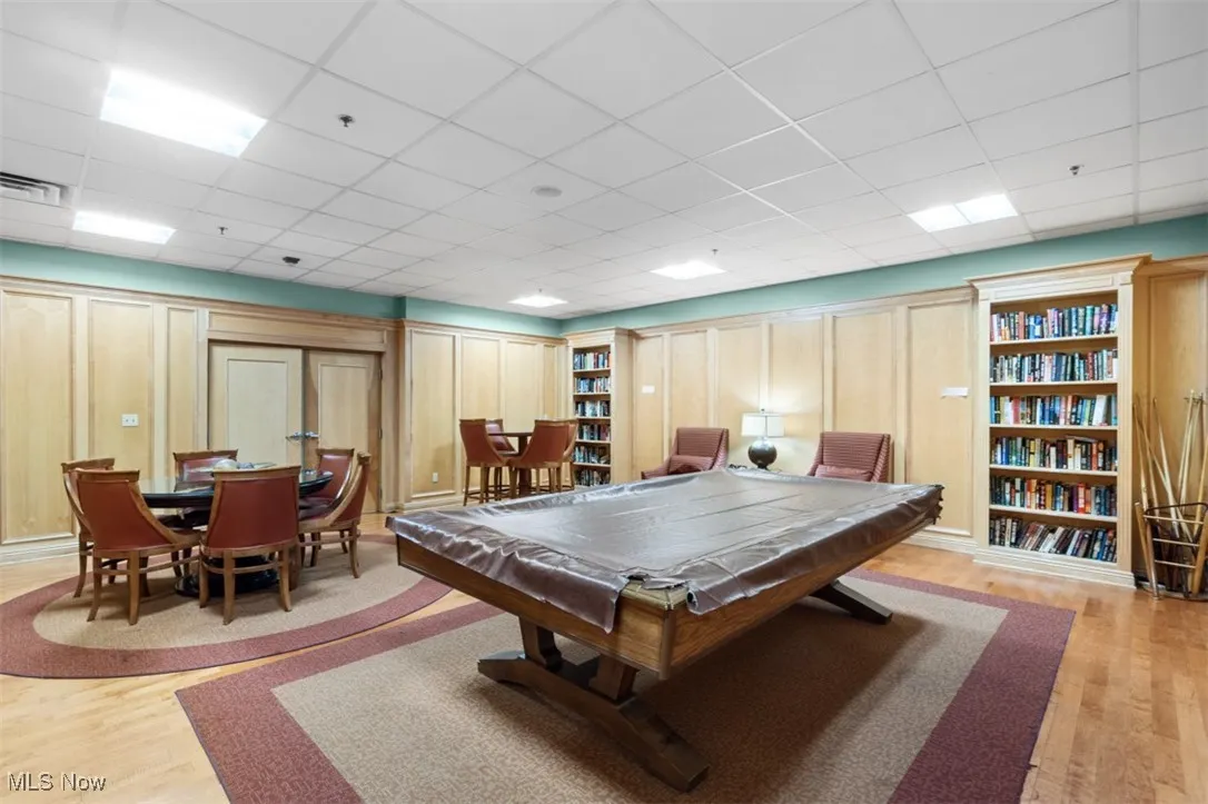 Rec room with a paneled ceiling, light wood finished floors, and pool table