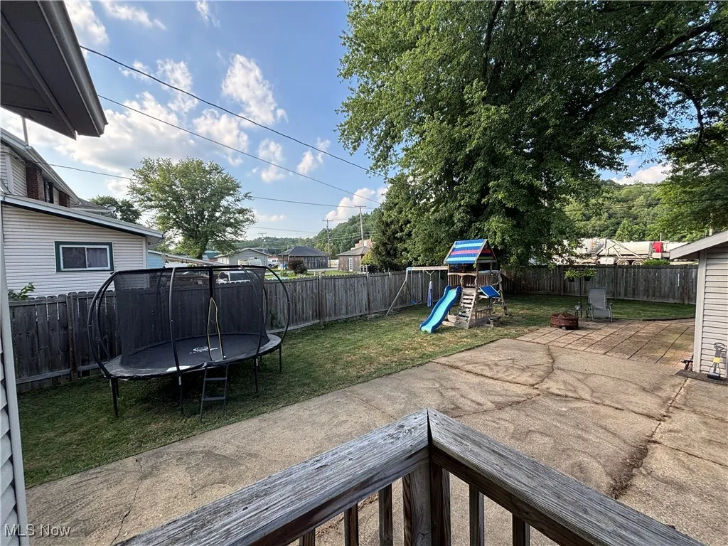 View of fenced in yard area with patio and yard