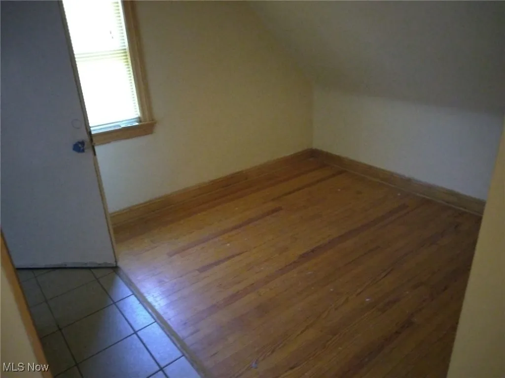 Bonus room featuring vaulted ceiling and light wood-style flooring