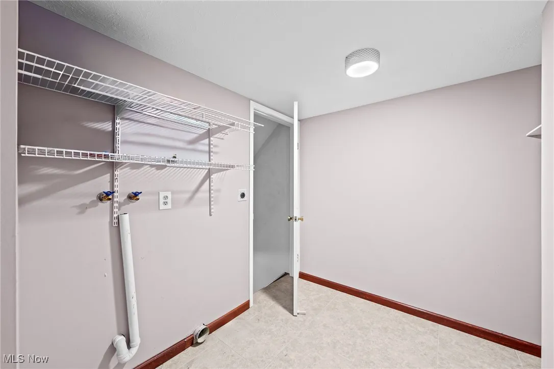 Washroom with electric dryer hookup and baseboards