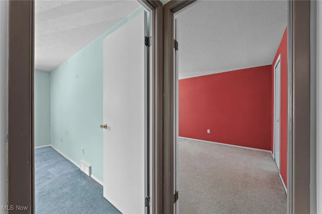 Corridor featuring a textured ceiling and carpet floors