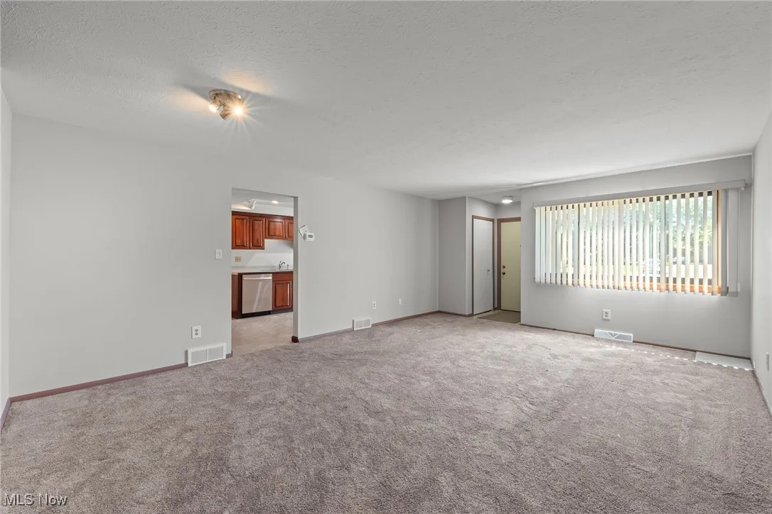 Spare room featuring a textured ceiling and light carpet