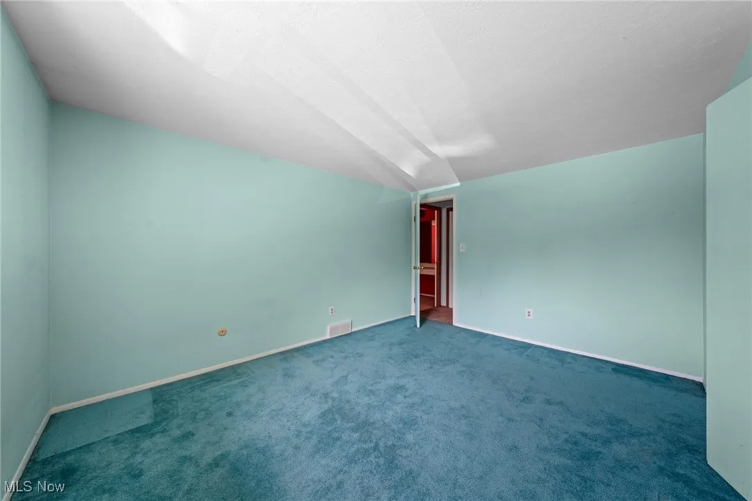 Unfurnished room with carpet flooring and baseboards