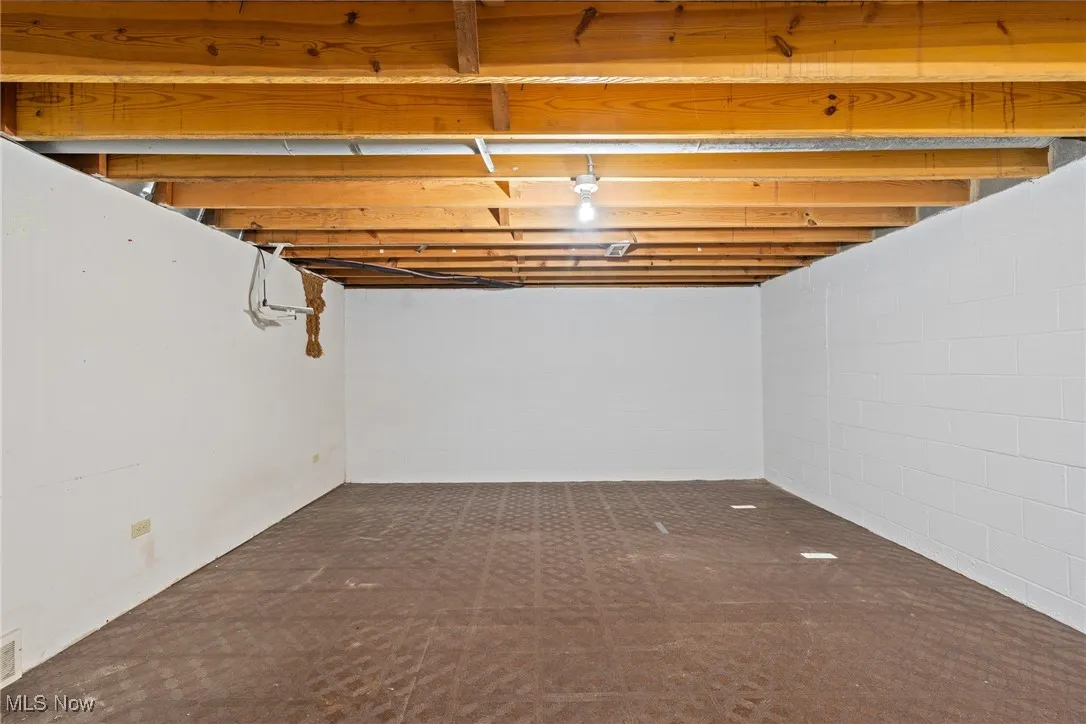 Unfinished below grade area featuring concrete block wall