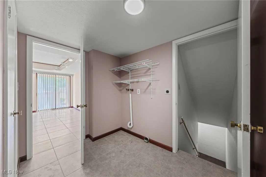 Washroom featuring light tile patterned flooring and a textured ceiling
