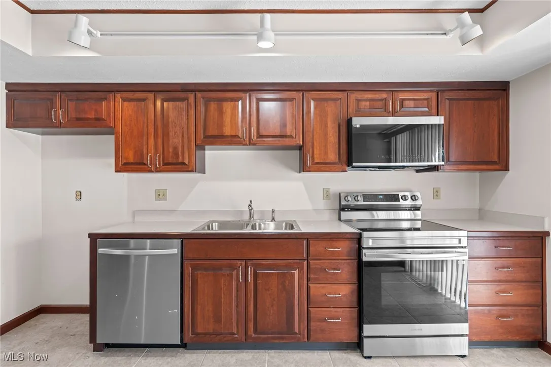 Kitchen featuring appliances with stainless steel finishes, light countertops, and light tile patterned floors