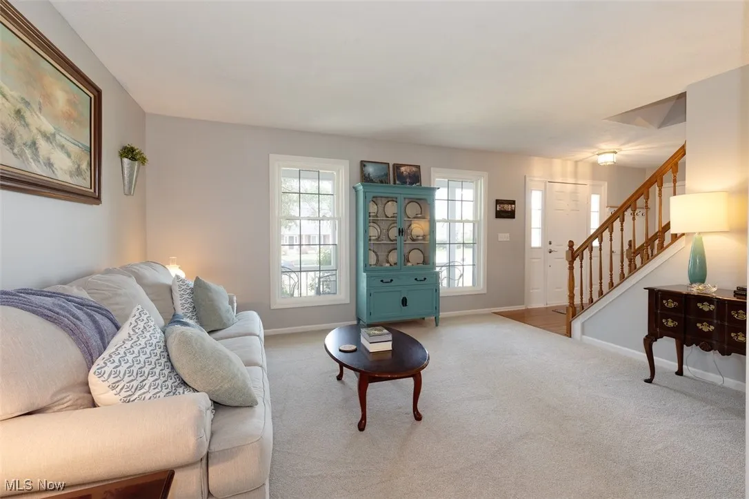 Living area with carpet floors and stairway