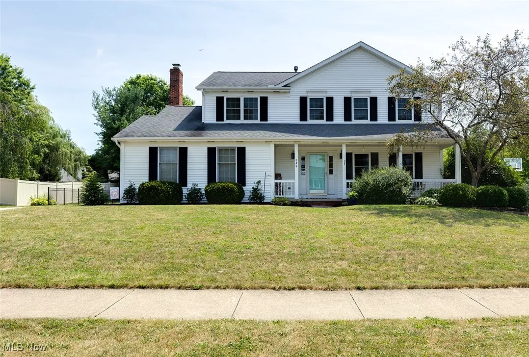 View of front facade with a chimney and covered porch