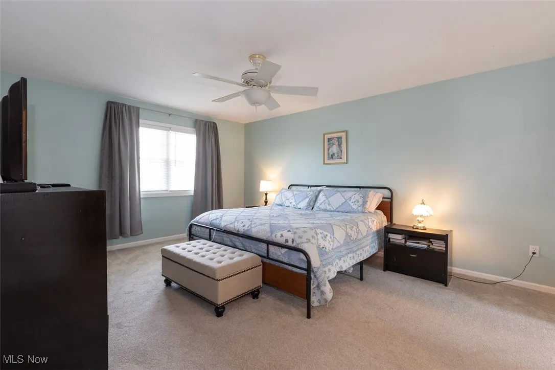 Carpeted bedroom with baseboards and a ceiling fan