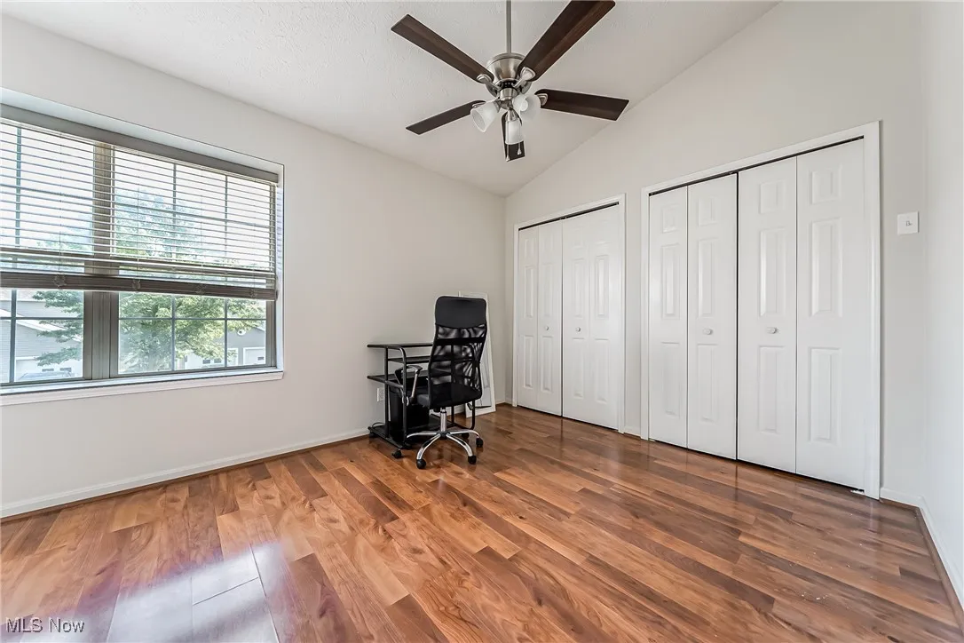Office area featuring vaulted ceiling, a ceiling fan, and wood finished floors