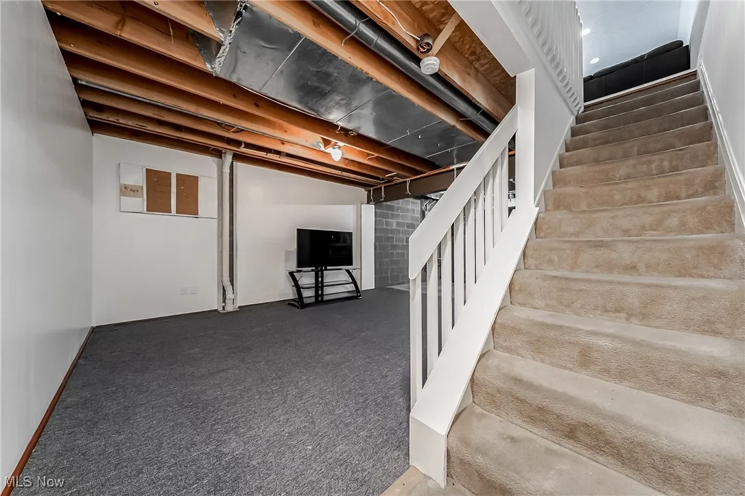 Finished basement with stairs and carpet floors