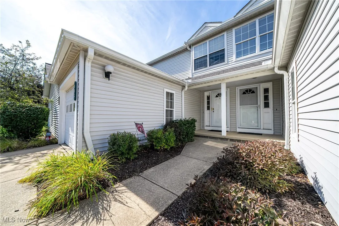 Doorway to property featuring a porch and concrete driveway