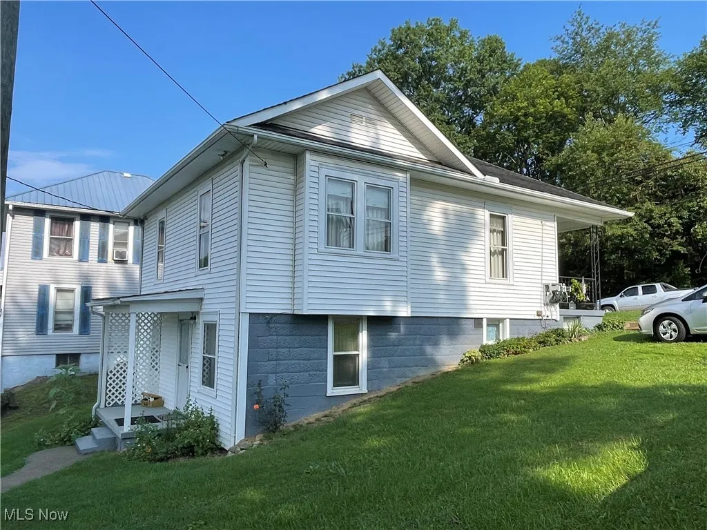 View of property exterior with a yard