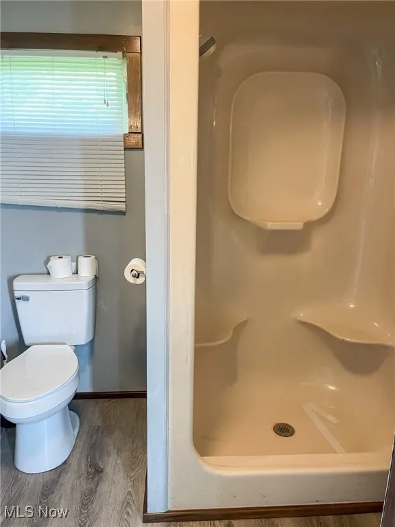 Full bath with wood finished floors and a shower