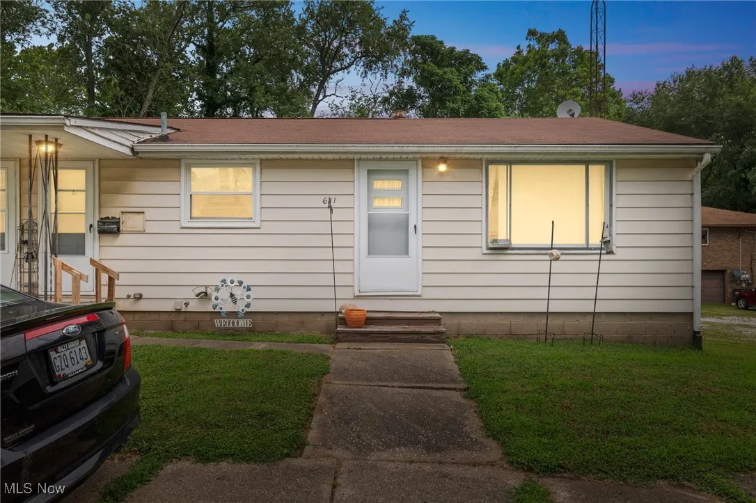 View of front of property with a lawn and entry steps
