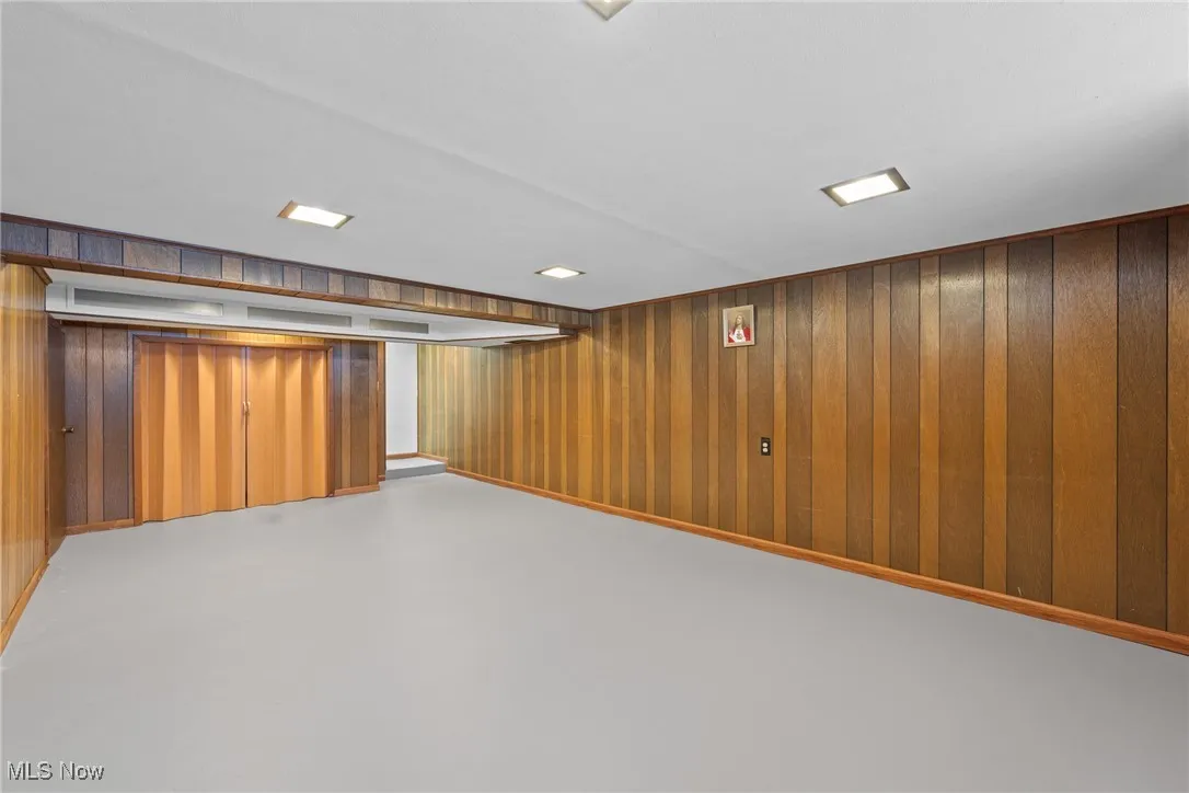 Finished basement with wooden walls and baseboards
