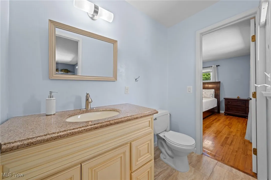 Bathroom with vanity, wood finished floors, and ensuite bathroom