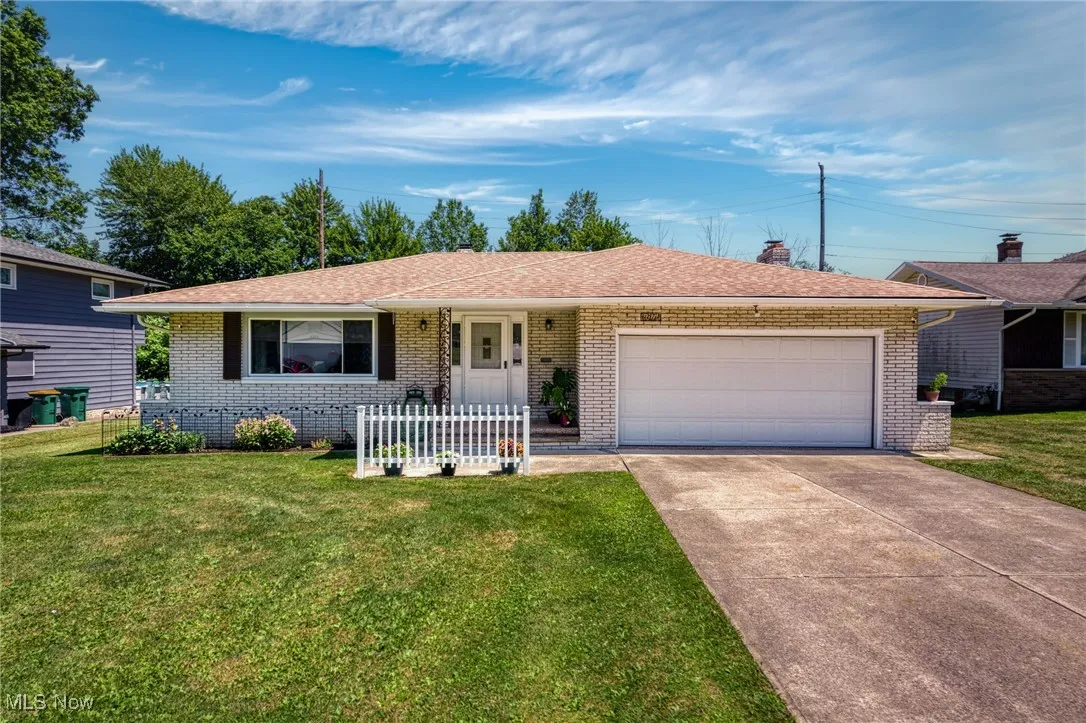 Ranch-style house with an attached garage, brick siding, driveway, and a front lawn