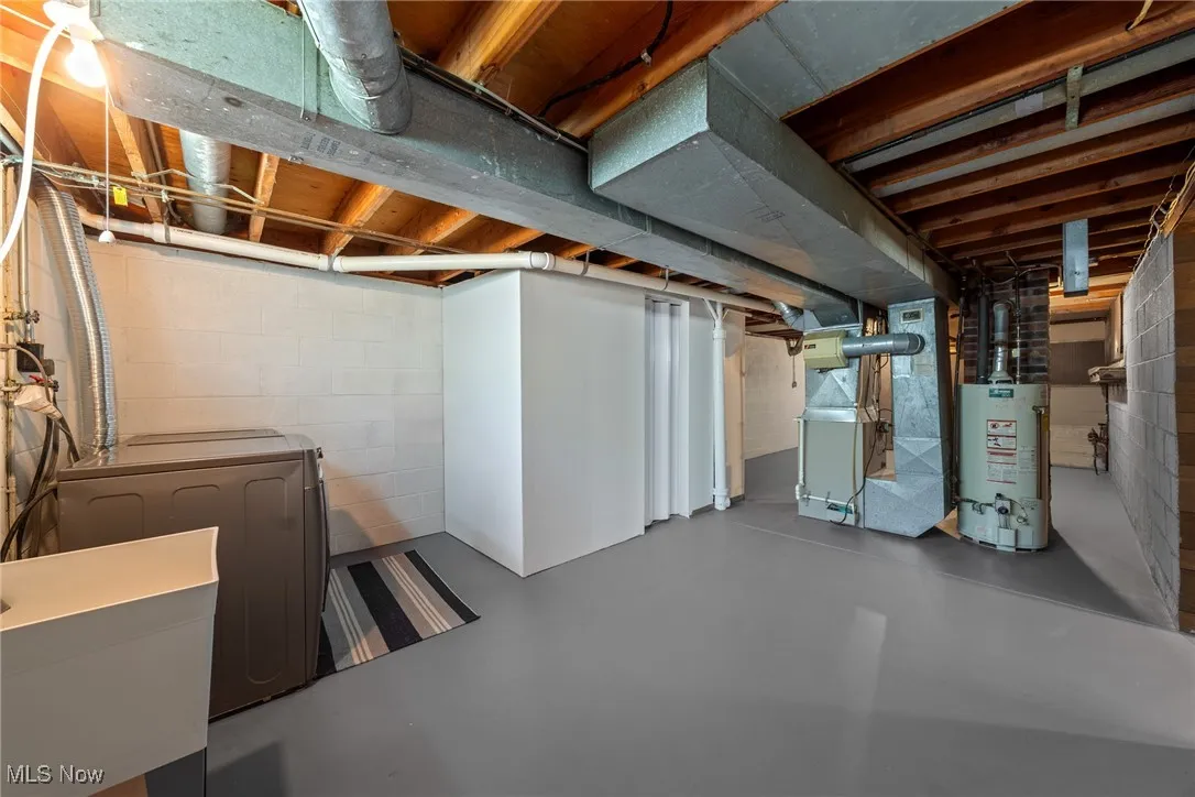 Unfinished below grade area with separate washer and dryer, heating unit, and gas water heater