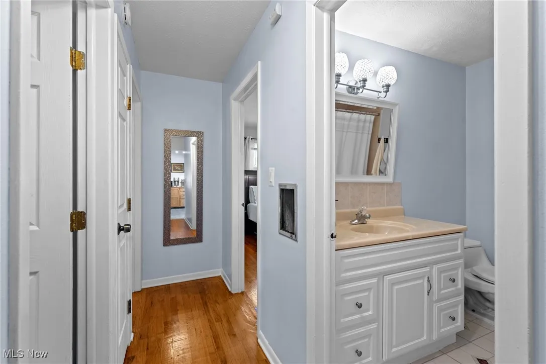 Bathroom featuring vanity, wood finished floors, and a textured ceiling
