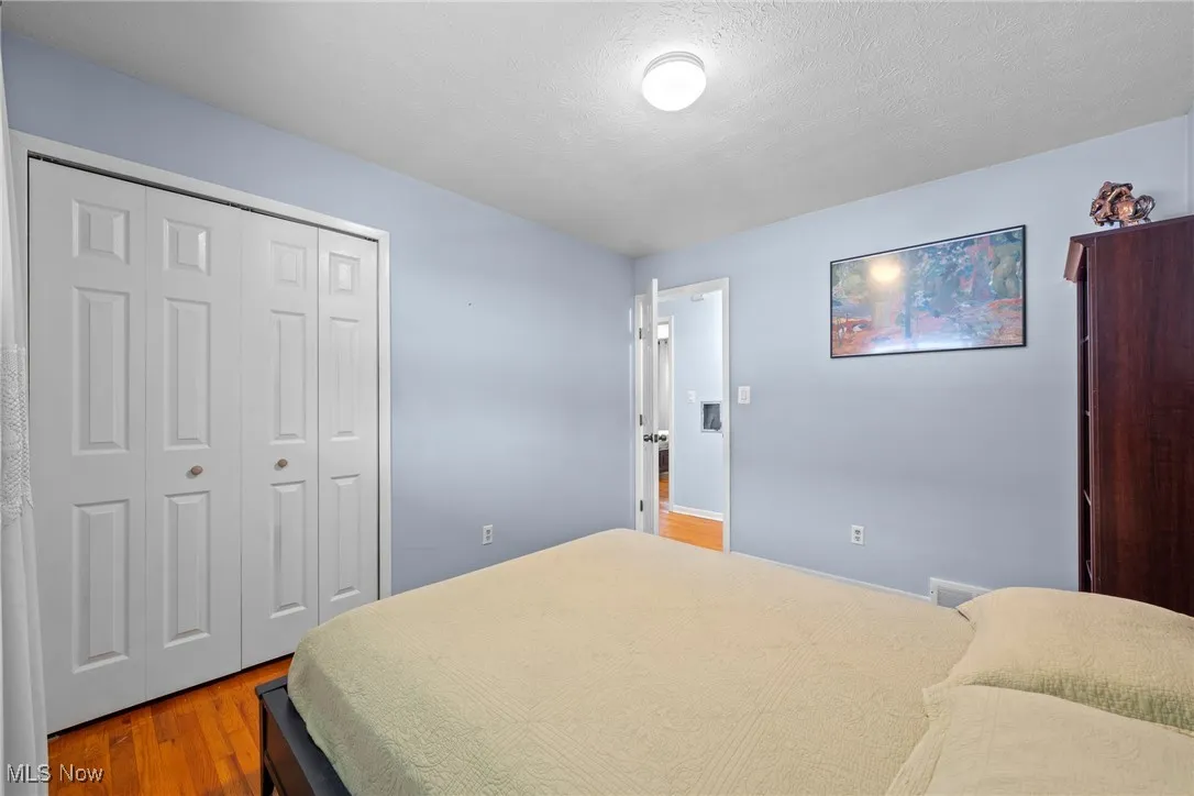 Bedroom featuring wood finished floors, a closet, and a textured ceiling