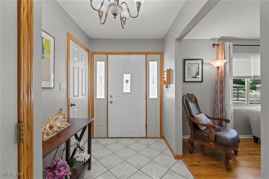Foyer entrance with a chandelier and light tile patterned flooring