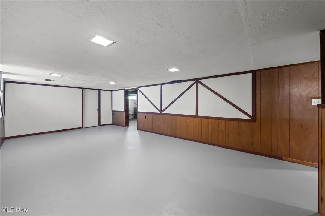 Basement featuring wood walls and a textured ceiling