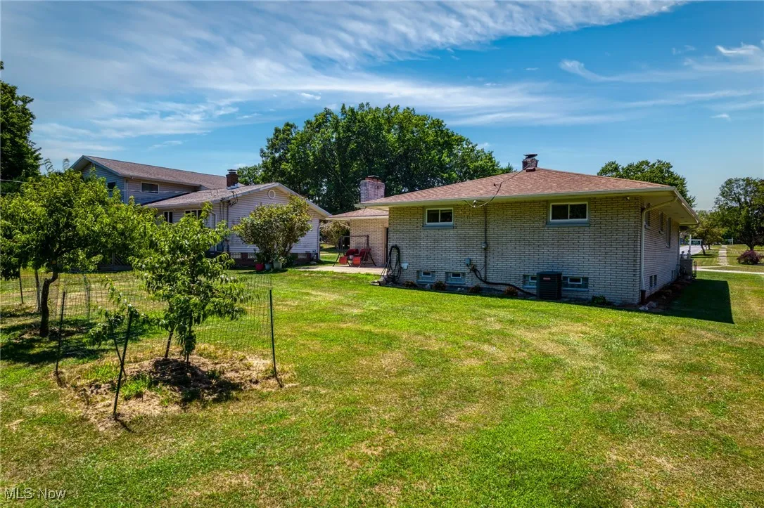 Rear view of house featuring brick siding and a chimney