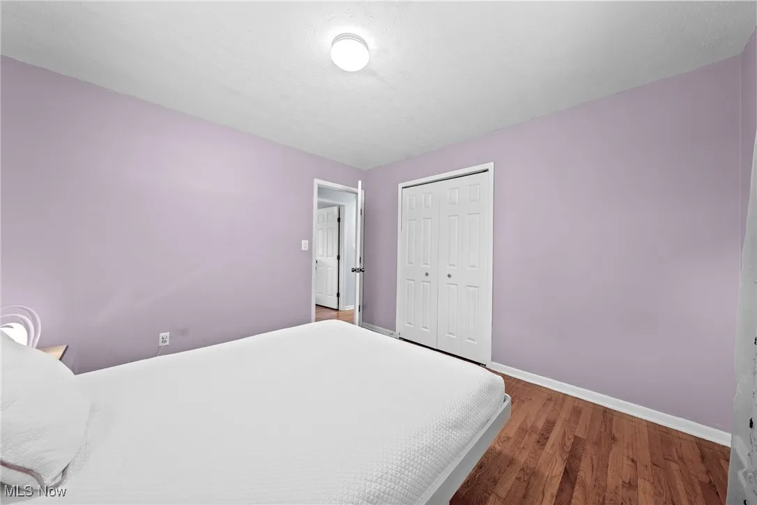 Bedroom with wood finished floors and a closet