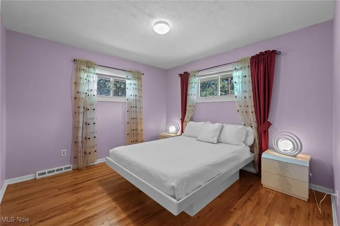 Bedroom with light wood-style floors and a textured ceiling
