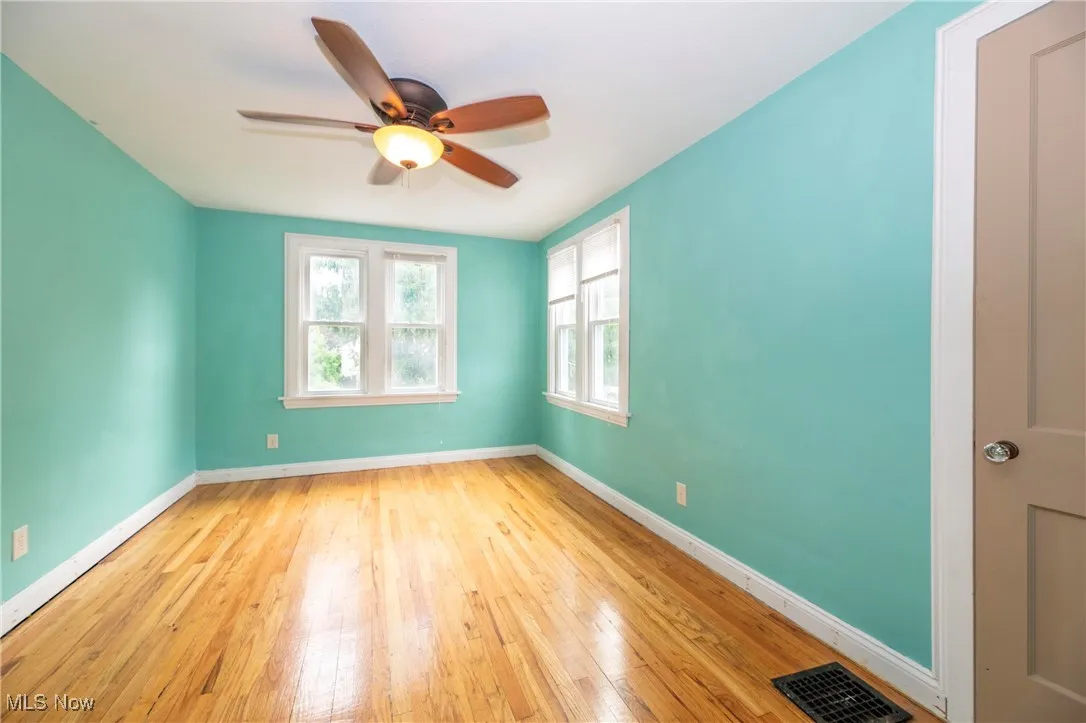 Upstairs bedroom with ceiling fan and hardwood flooring