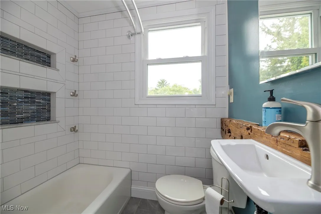 Second floor full Bathroom with bathtub / shower combination and tile walls