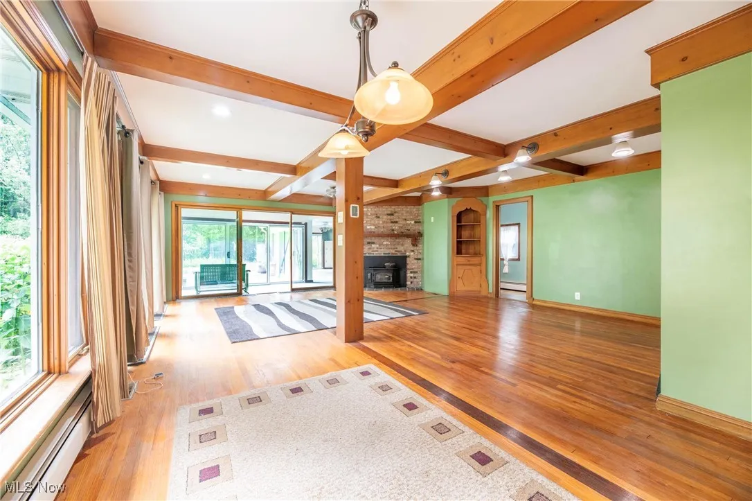 Dining room featuring beam ceiling, hardwood flooring and a chandelier