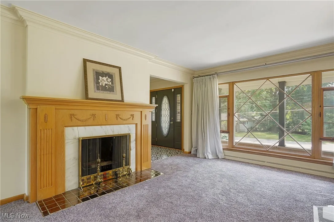 Unfurnished living room featuring carpet, crown molding, and a premium fireplace