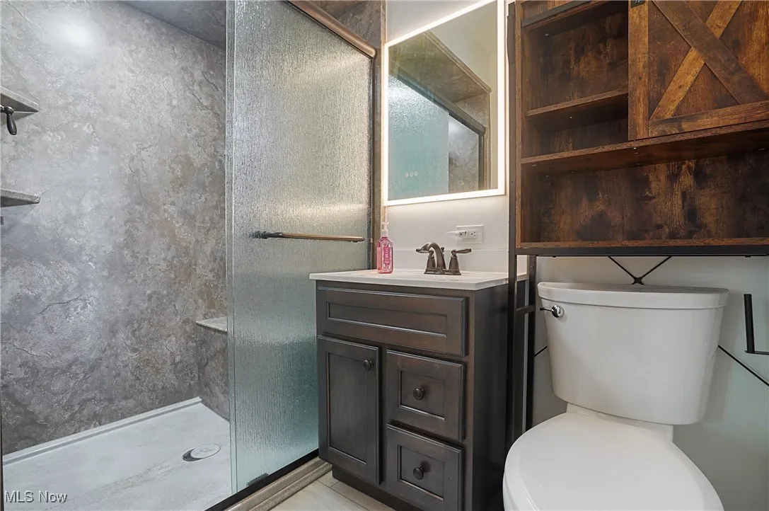 Full bath with a shower stall and vanity