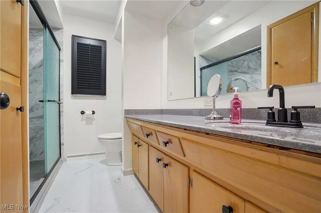 Full bathroom featuring marble finish floors, vanity, and a marble finish shower