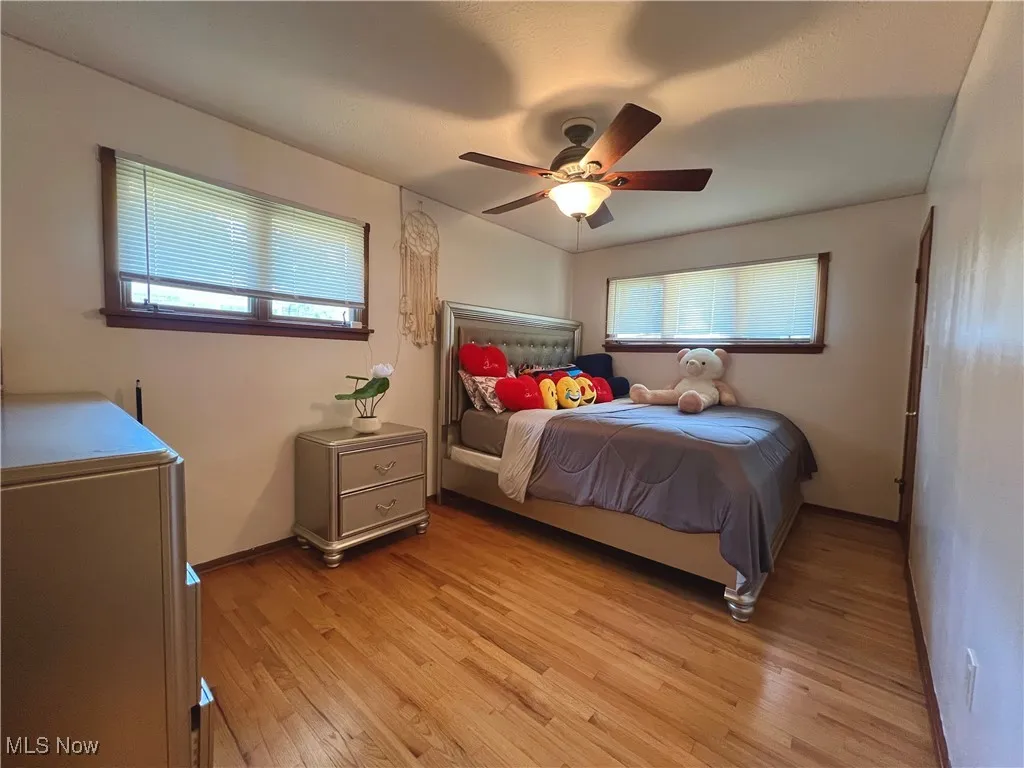 Bedroom with light wood finished floors and a ceiling fan