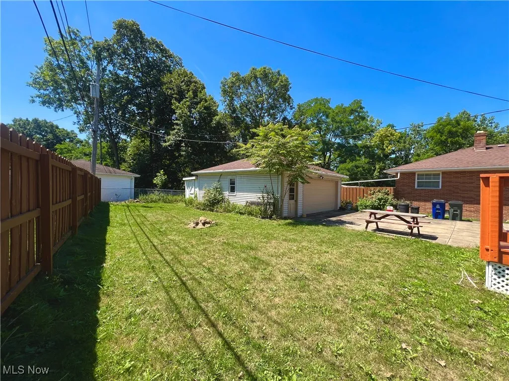 Fenced yard featuring an outdoor structure and a detached garage
