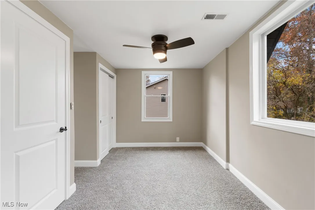 Unfurnished bedroom with light carpet, a ceiling fan, and a closet
