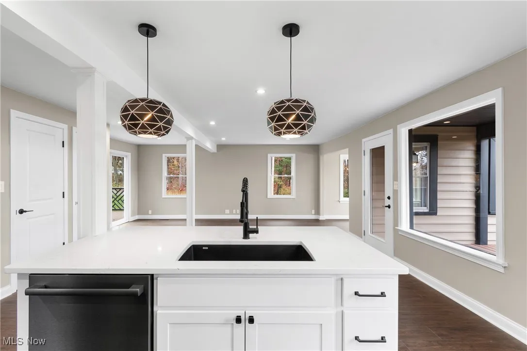 Kitchen featuring open floor plan, dishwashing machine, recessed lighting, dark wood-style flooring, and hanging light fixtures