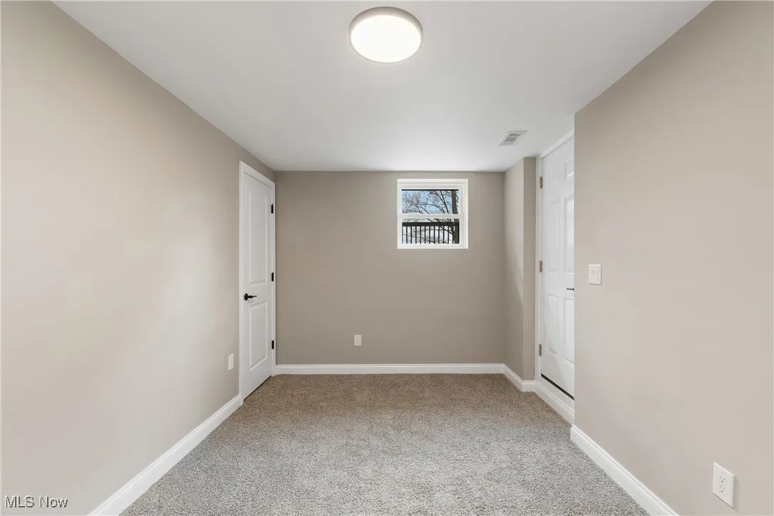 Carpeted spare room featuring baseboards