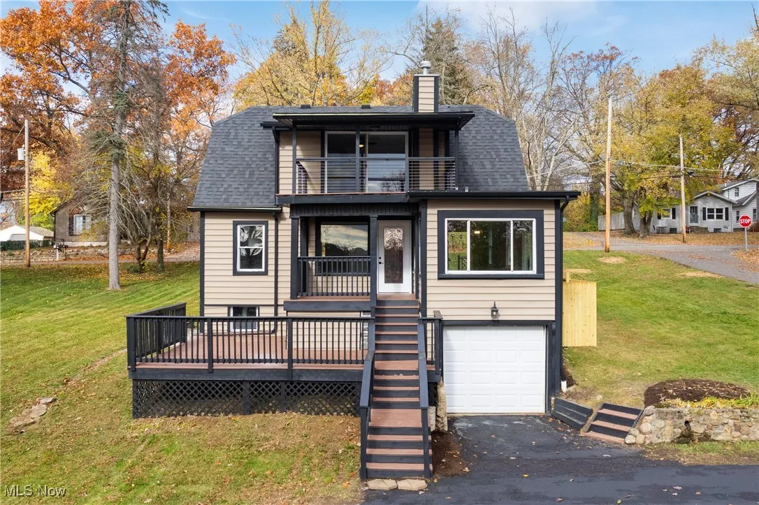 Back of house with a balcony, a garage, roof with shingles, and a chimney