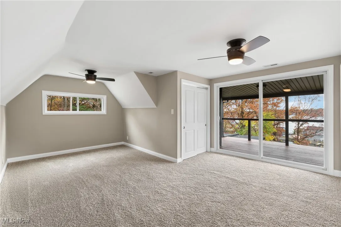 Bonus room with ceiling fan, carpet, and vaulted ceiling