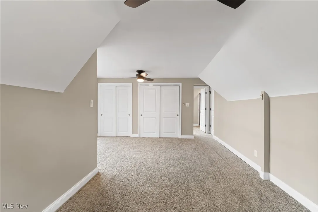 Bonus room with ceiling fan, vaulted ceiling, and carpet flooring