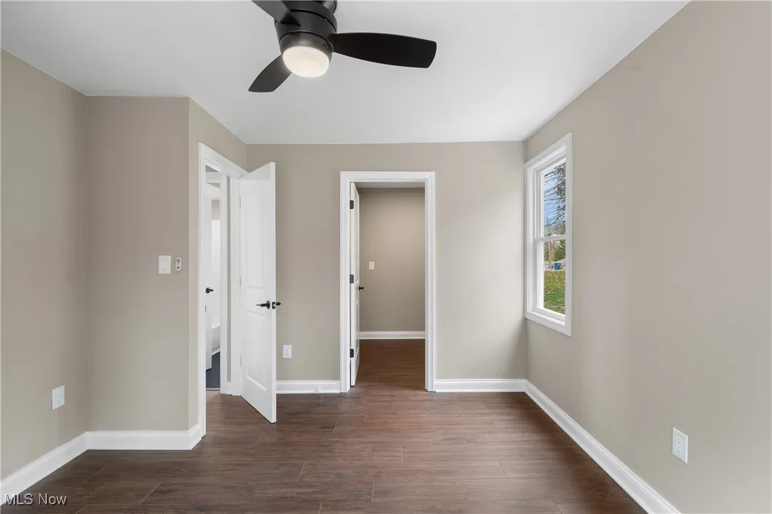 Unfurnished bedroom with dark wood finished floors and a ceiling fan