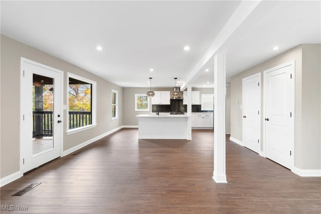 Unfurnished living room with recessed lighting and dark wood-style floors