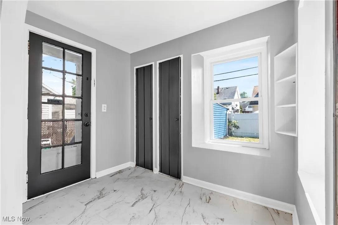 Entryway featuring baseboards and marble finish flooring