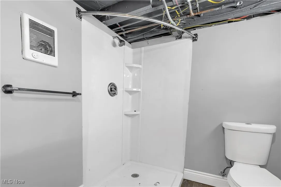 Full bath with toilet and a stall shower